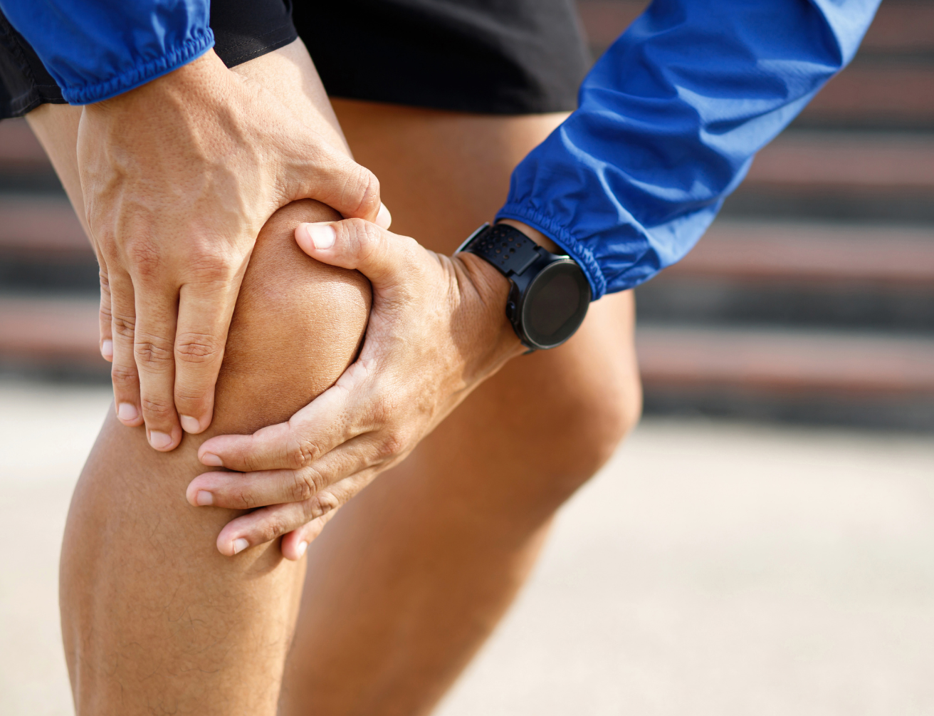 Persona sujetándose la rodilla con signos de dolor